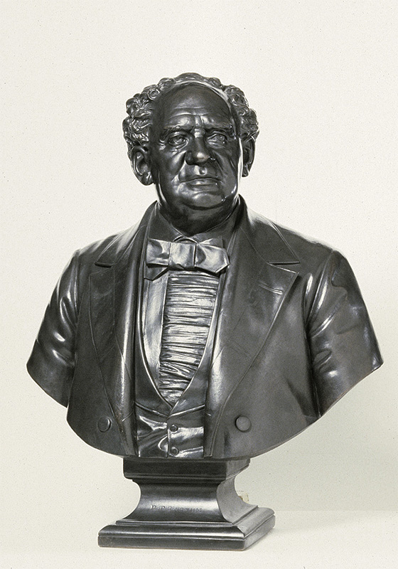 bust length sculpted portrait of a man in a suit with curly hair