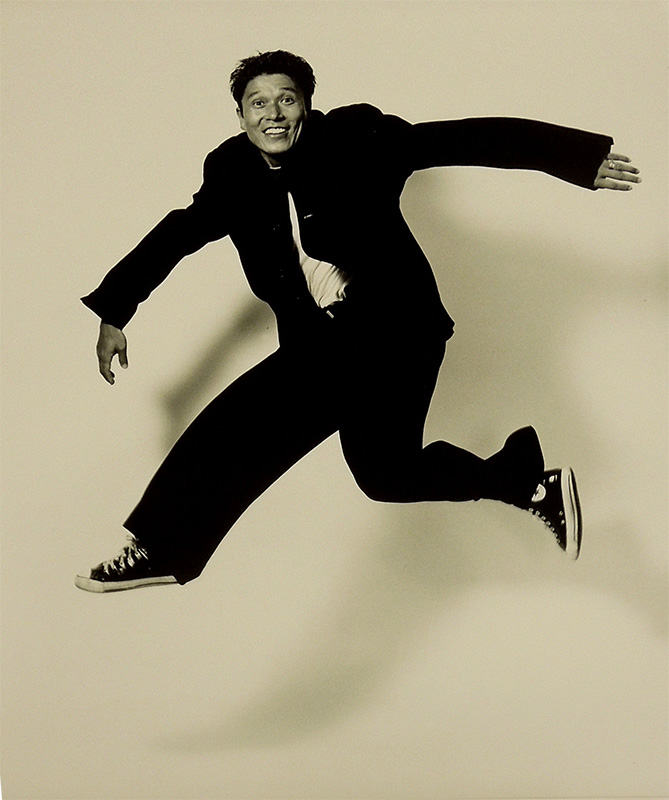 dancing man in a black suit in mid-air