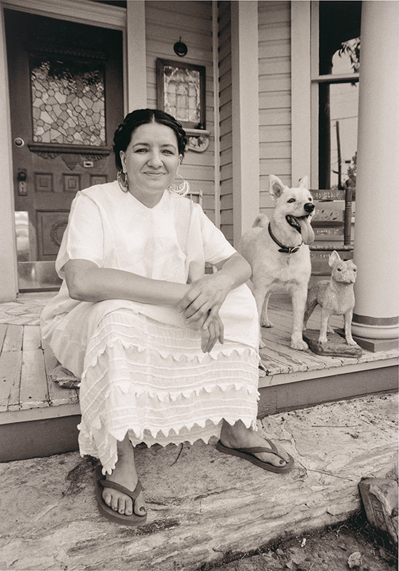 woman in a white dress sitting on her porch with her dog