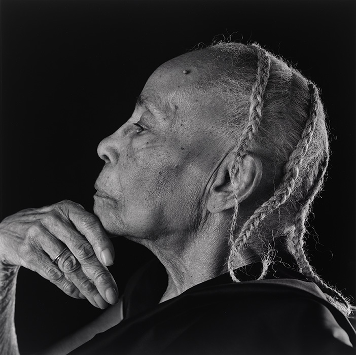 Profile portrait of an older Black woman with her hand under her chin