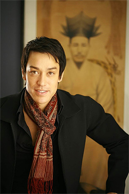 waist length photo of a young Asian man in a black sweater and patterned scarf