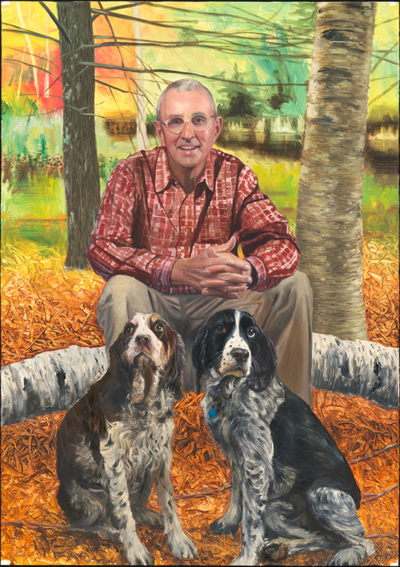 man in a checkered shirt seated outdoors with two dogs