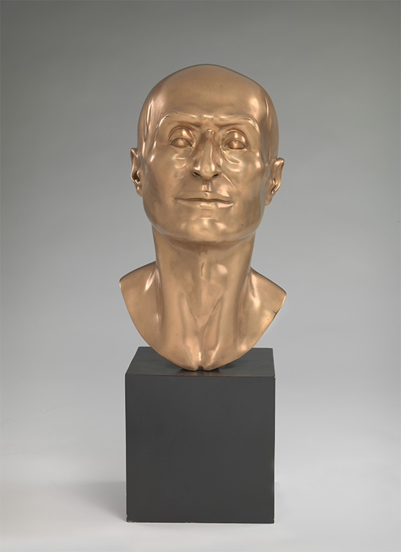 head-length gold sculpture of a bald man