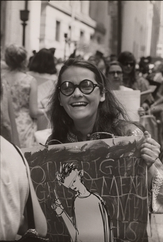 Woman wearing large glasses in the midst of a protest march