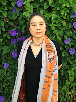 Woman in a tiger scarf standing amidst morning glories