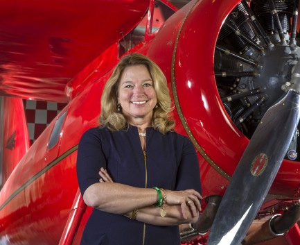 Woman in black standing in front of a red plane
