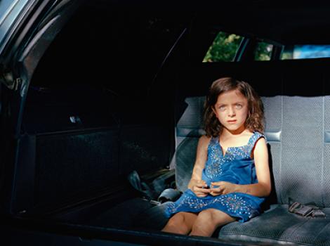 Little girl sitting in the backseat of a car
