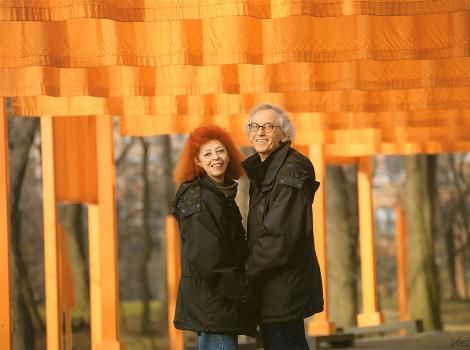 Man and woman standing under bright orange banners