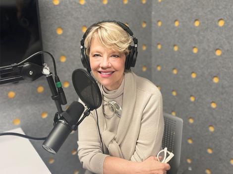 Woman seated in a podcast studio