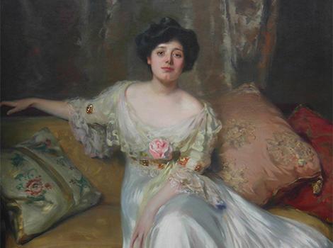 19th century woman in a white gown on a pillowed couch