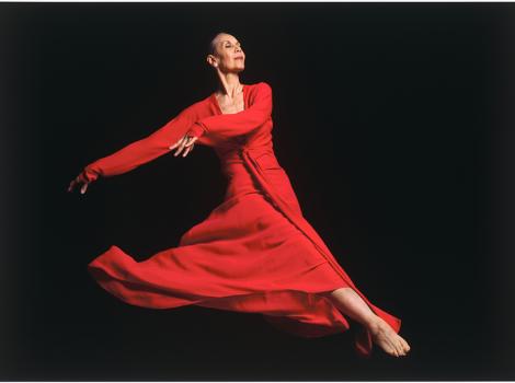 ballet dancer in a red dress mid-jump