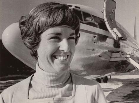 smiling woman in short hair standing in front of an airline