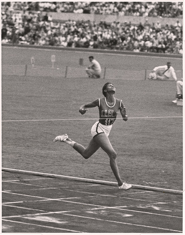 black and white photo of a woman running a relay