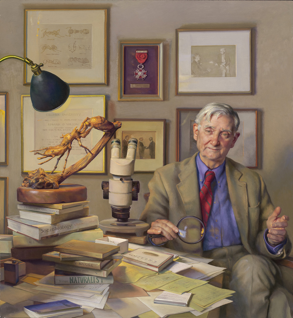 scholarly man seated at a desk with insect specimens